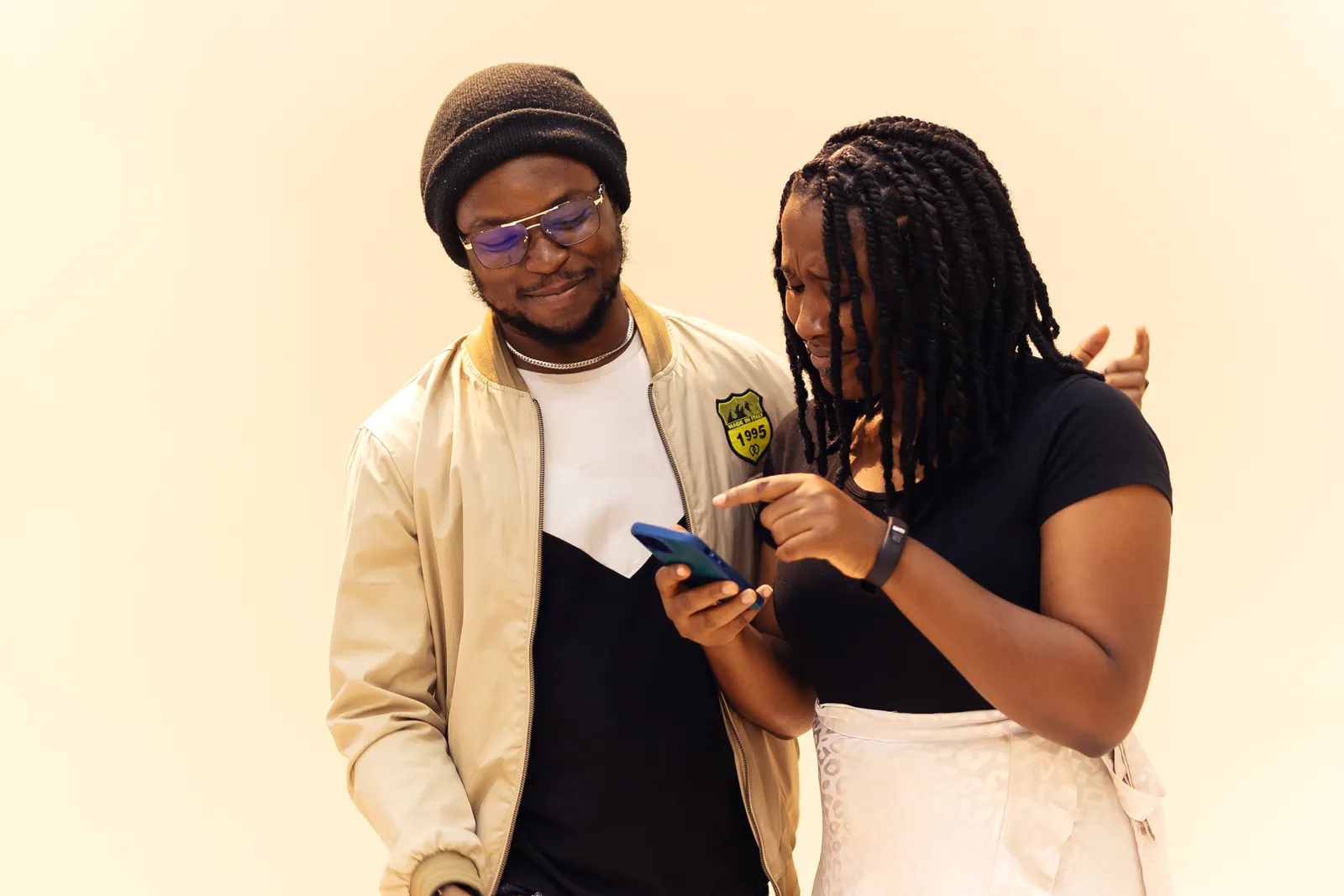 Un couple souriant partageant un moment autour d’un smartphone à Lagos