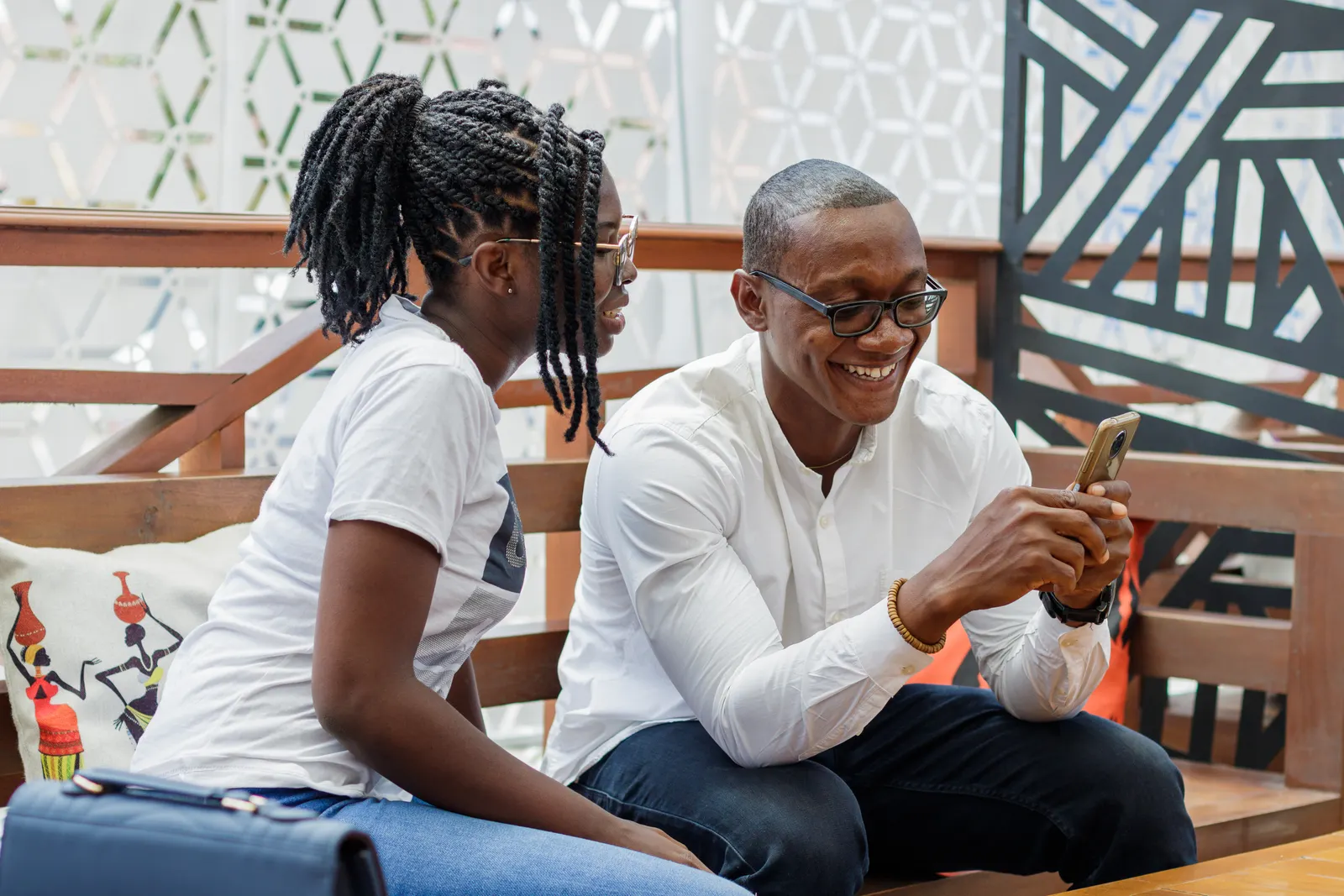 Un couple heureux utilisant ensemble un smartphone à l’extérieur