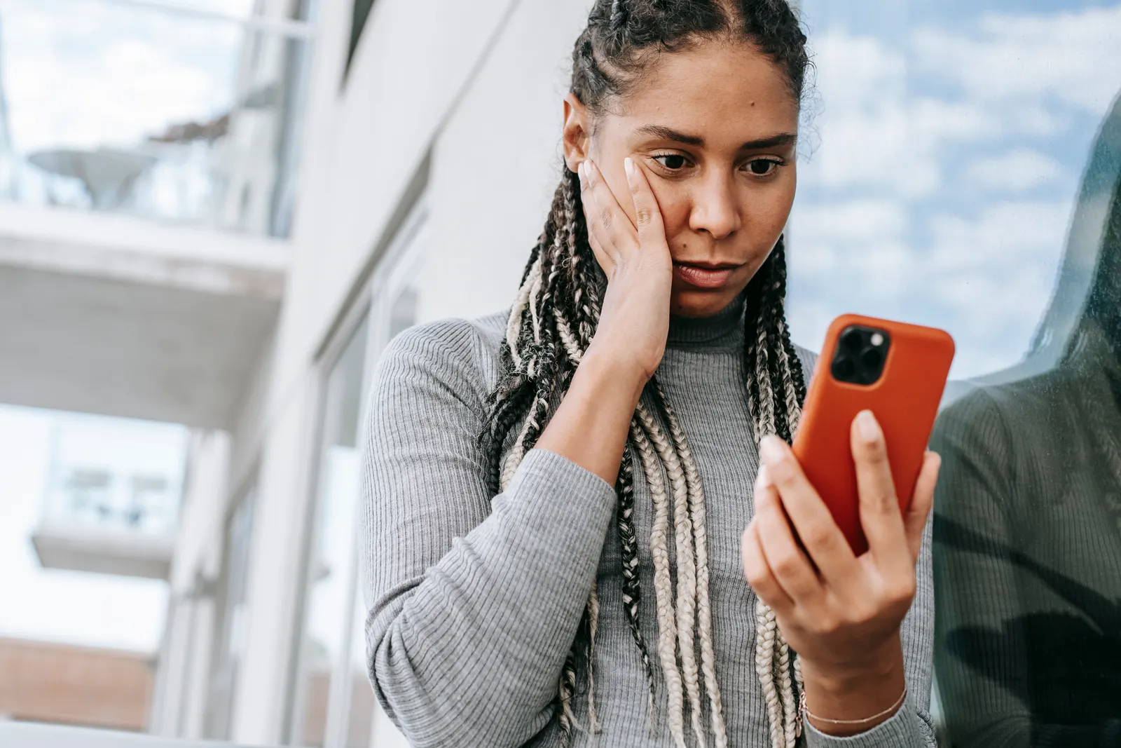 Une femme examinant attentivement des informations sur son smartphone
